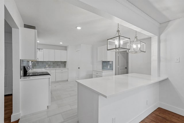 kitchen with sink, white cabinetry, tasteful backsplash, decorative light fixtures, and kitchen peninsula