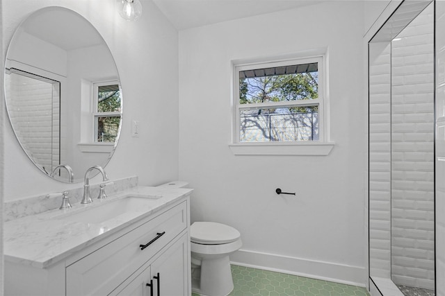 bathroom featuring a healthy amount of sunlight, toilet, vanity, and a shower