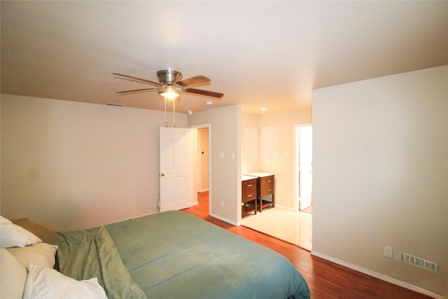 bedroom with connected bathroom, wood-type flooring, and ceiling fan