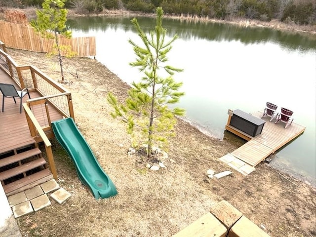 exterior space featuring a deck with water view and fence