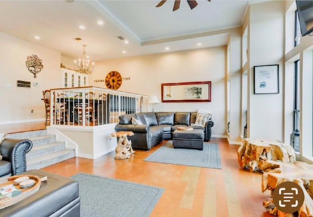 living room with visible vents, baseboards, wood finished floors, recessed lighting, and an inviting chandelier