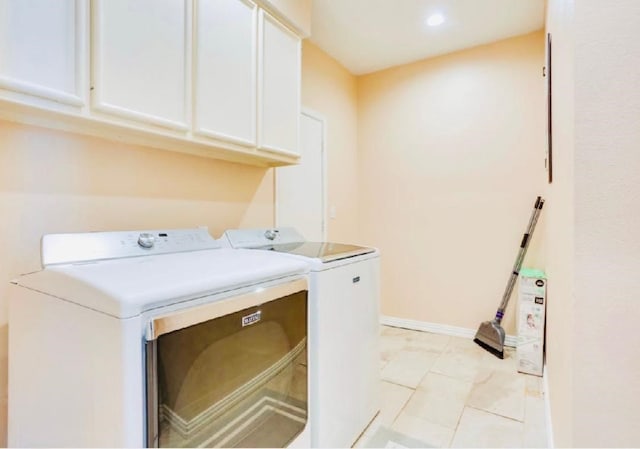 laundry area with baseboards, cabinet space, and washer and clothes dryer