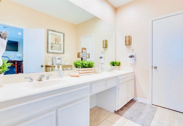 full bathroom featuring tile patterned floors, double vanity, a sink, and baseboards