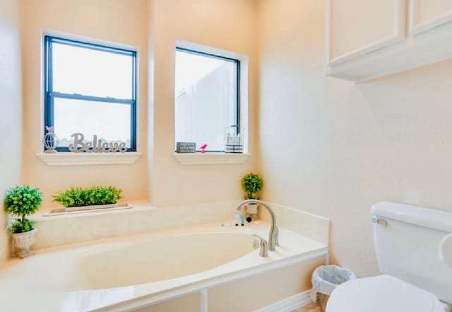 full bath featuring toilet and a garden tub