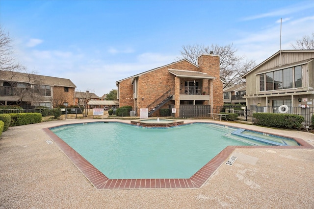 view of pool with a community hot tub and a patio area