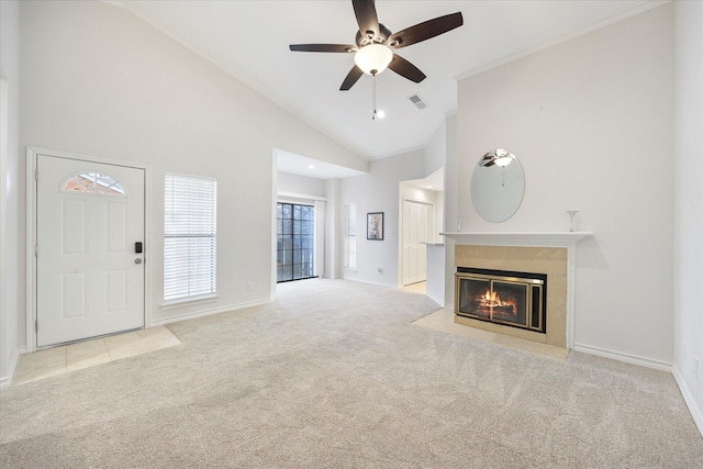 unfurnished living room featuring crown molding, a premium fireplace, ceiling fan, high vaulted ceiling, and light carpet