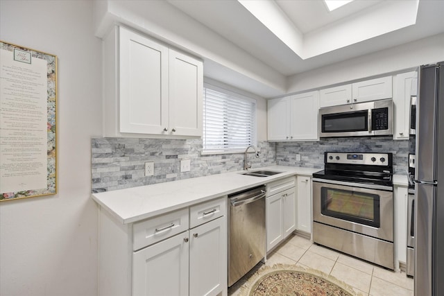 kitchen with stainless steel appliances, sink, white cabinets, and decorative backsplash