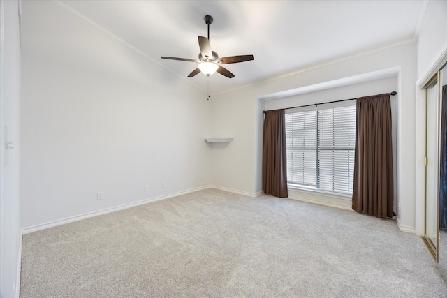 carpeted empty room featuring crown molding and ceiling fan