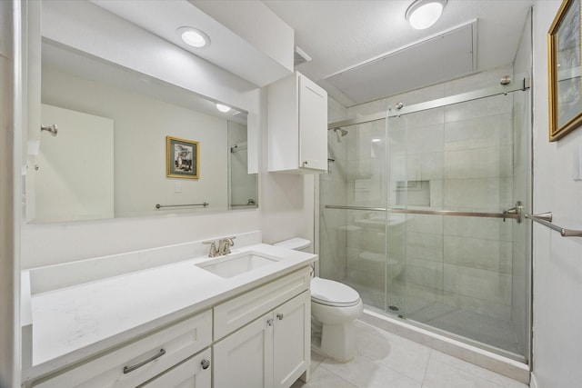 bathroom with vanity, tile patterned flooring, a shower with shower door, and toilet