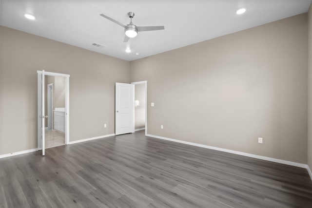 unfurnished bedroom with dark wood-type flooring, connected bathroom, and ceiling fan