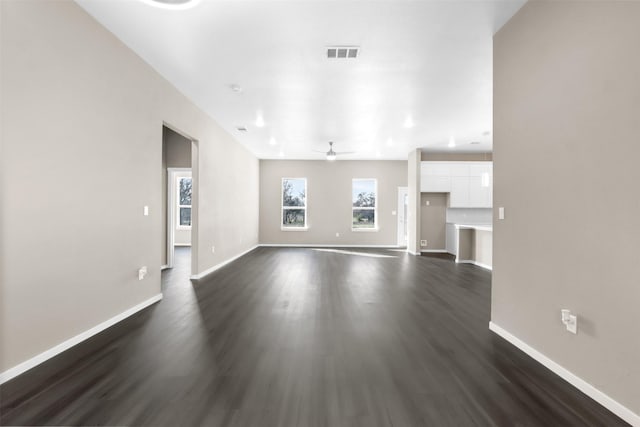 unfurnished living room featuring ceiling fan and dark hardwood / wood-style flooring