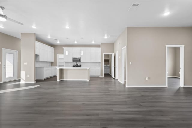 unfurnished living room featuring dark hardwood / wood-style flooring and ceiling fan