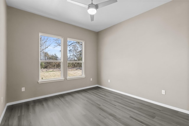 spare room featuring dark wood-type flooring and ceiling fan