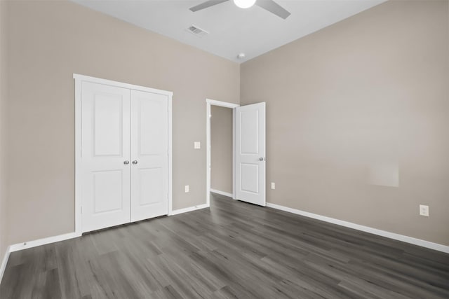 unfurnished bedroom with ceiling fan, dark hardwood / wood-style flooring, and a closet