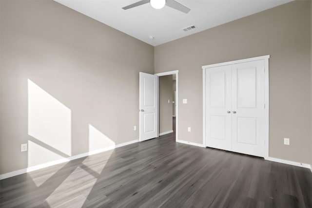 unfurnished bedroom featuring dark hardwood / wood-style flooring, a closet, and ceiling fan