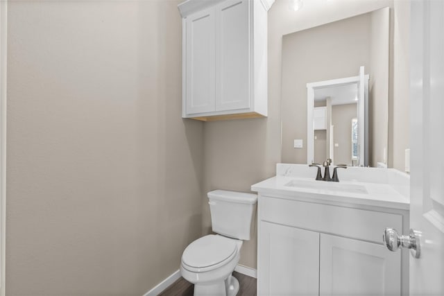 bathroom featuring vanity, hardwood / wood-style flooring, and toilet