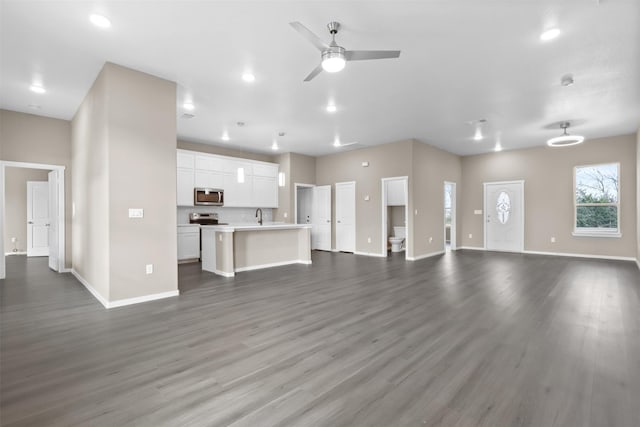 unfurnished living room with ceiling fan, dark hardwood / wood-style floors, and sink