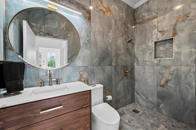 bathroom with toilet, tile walls, a tile shower, ornamental molding, and vanity