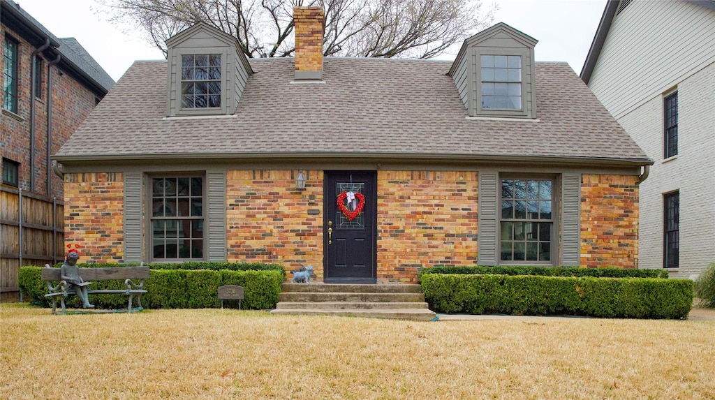 new england style home featuring a front lawn