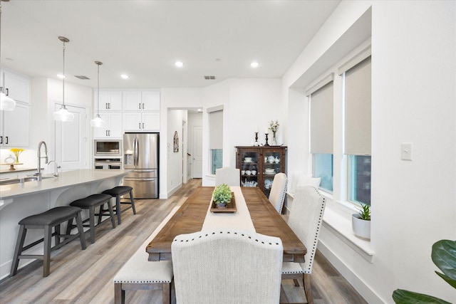 dining space with wood-type flooring and sink