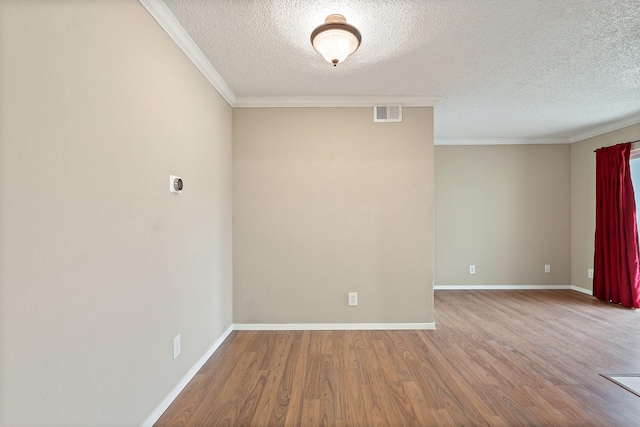 unfurnished room with crown molding, hardwood / wood-style floors, and a textured ceiling