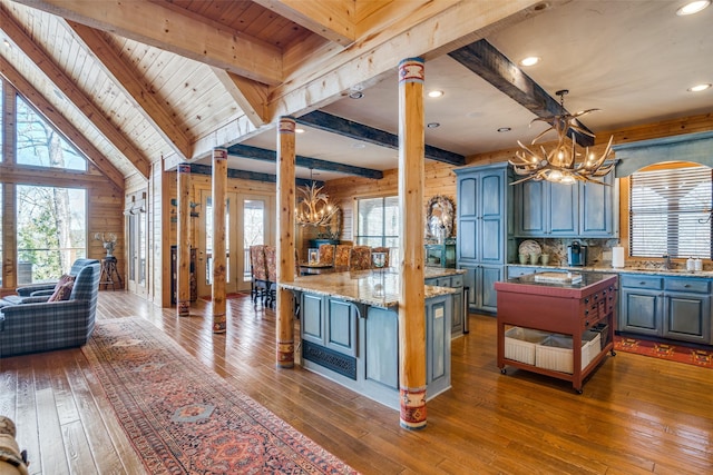 kitchen with ornate columns, decorative light fixtures, a center island, and a notable chandelier