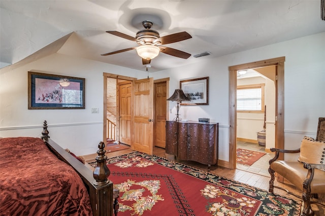 bedroom with ceiling fan, ensuite bathroom, and light hardwood / wood-style floors