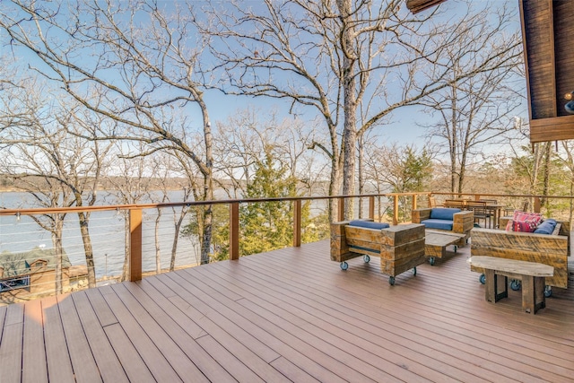 wooden terrace with a water view and outdoor lounge area