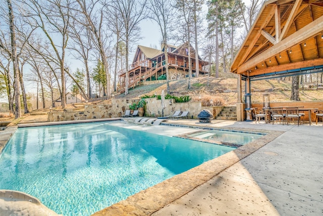 view of swimming pool featuring an in ground hot tub and a patio