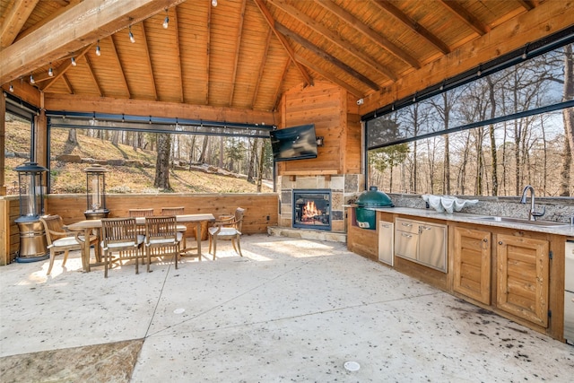 view of patio / terrace featuring sink, an outdoor stone fireplace, a gazebo, grilling area, and an outdoor kitchen