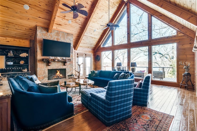 living room featuring a healthy amount of sunlight, wood-type flooring, beam ceiling, and wooden ceiling