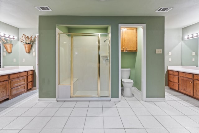 bathroom featuring vanity, an enclosed shower, tile patterned floors, and toilet