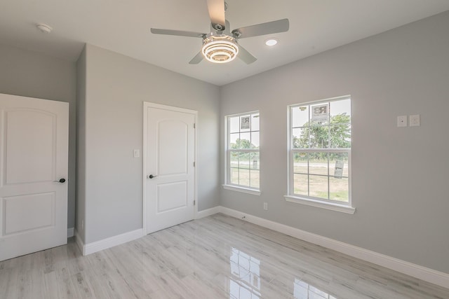 spare room with ceiling fan and light wood-type flooring