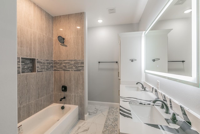 bathroom featuring vanity and tiled shower / bath