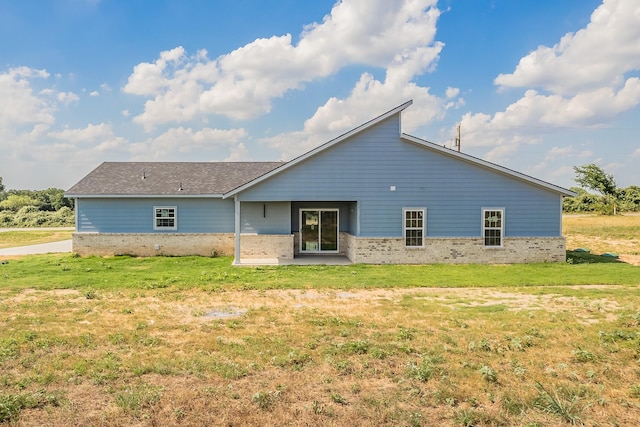 back of house featuring a lawn and a patio