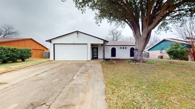 ranch-style home with a garage, central AC unit, and a front yard