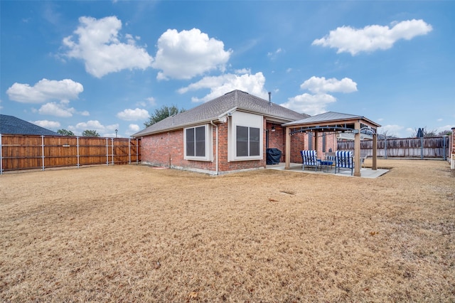 rear view of house with a gazebo, a yard, and a patio area