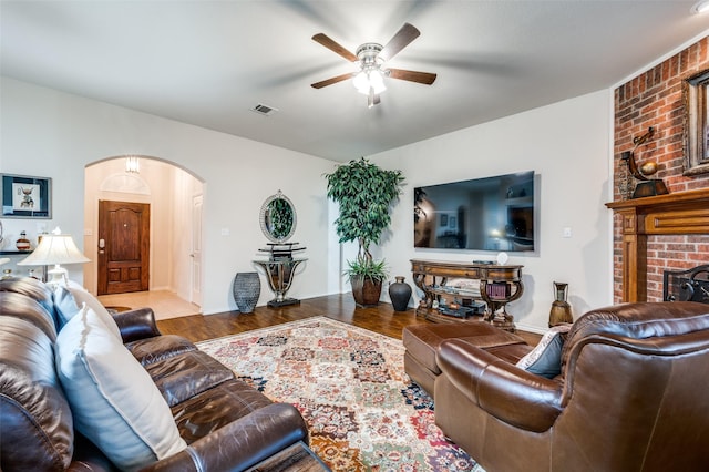 living room with ceiling fan, a fireplace, and light hardwood / wood-style flooring
