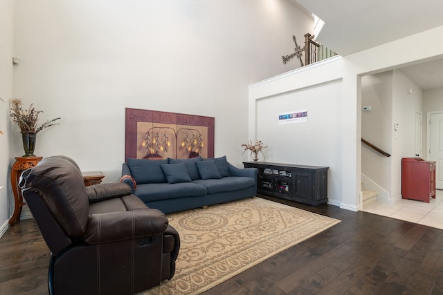 living room featuring wood-type flooring and a towering ceiling