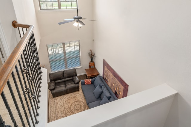 living room featuring ceiling fan and a high ceiling