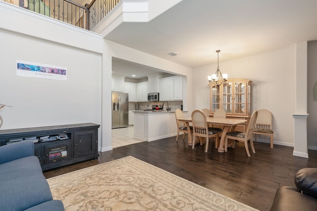 dining area featuring light wood-type flooring, an inviting chandelier, and sink