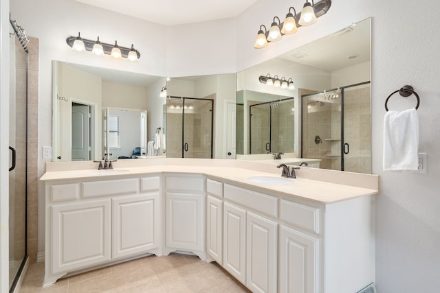 bathroom featuring tile patterned floors, an enclosed shower, and vanity