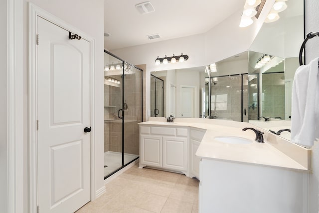 bathroom featuring tile patterned flooring, an enclosed shower, and vanity