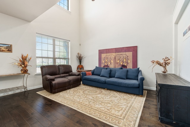 living room with dark hardwood / wood-style flooring and a towering ceiling