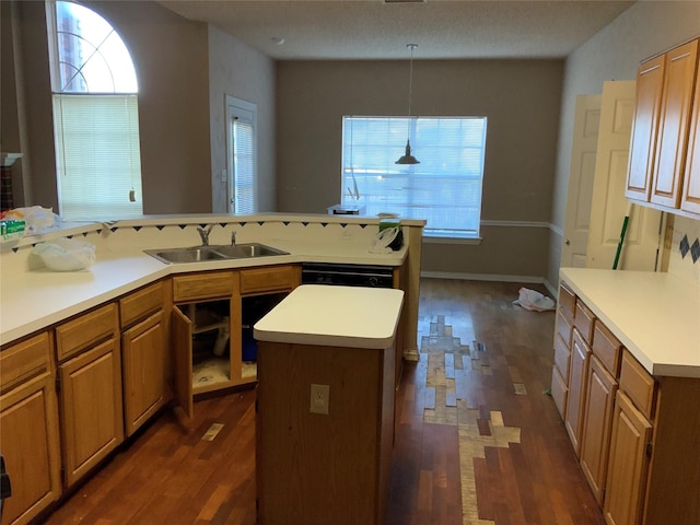 kitchen featuring dark hardwood / wood-style floors, a kitchen island, sink, and hanging light fixtures