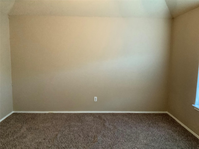 carpeted empty room featuring lofted ceiling