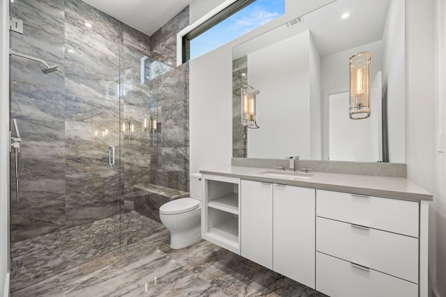 bathroom featuring vanity, toilet, and a shower with shower door