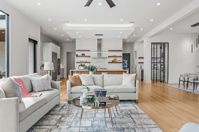 living room with ceiling fan and light hardwood / wood-style flooring