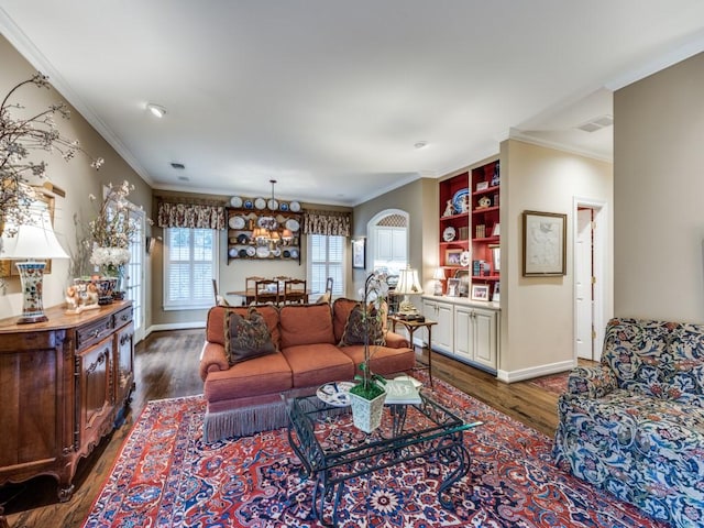 living room featuring dark hardwood / wood-style flooring, crown molding, and a chandelier