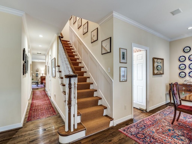 foyer entrance with crown molding and dark hardwood / wood-style flooring